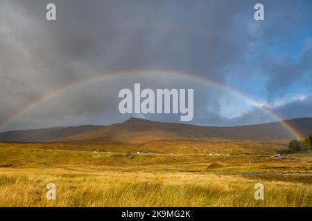 Arcobaleno sul traffico sulla strada A82 attraverso Glen Coe, Scozia, Regno Unito Foto Stock