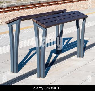 Panchine di appoggio o bancarelle di appoggio o sbarre di appoggio (ancora nessun nome stabilito) - nuova sostituzione moderna della panca tradizionale sulle stazioni ferroviarie, autobus o tr Foto Stock