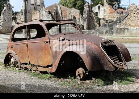 I resti di una Peugeot 202 auto distrutta nel villaggio di Oradour-sur-Glane nell'Haute-Vienne, Francia Foto Stock