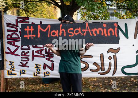 22.10.2022, Berlino, Germania, Europa - un attivista ha un segno di solidarietà con l'hashtag e il nome della defunta donna iraniana Mahsa Amini. Foto Stock