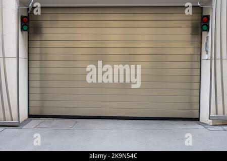 Primo piano di metallo chiuso deposito sezionale porta di garage vialetto con semafori come concetto per il parcheggio sotterraneo e ingresso garage gateway indietro Foto Stock