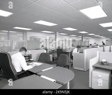 1989, dipendenti storici dell'azienda che lavorano alle scrivanie in cubicoli condivisi, in un ufficio aperto comune in quest'epoca, Inghilterra, Regno Unito, con il manager seduto in una grande scrivania semicircolare, che si affaccia sul pavimento. Foto Stock