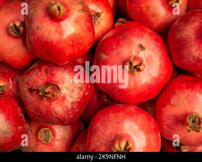 Melograni sul banco. Frutti rossi maturi. Stallo del mercato. Sfondo da melograni interi. Foto Stock