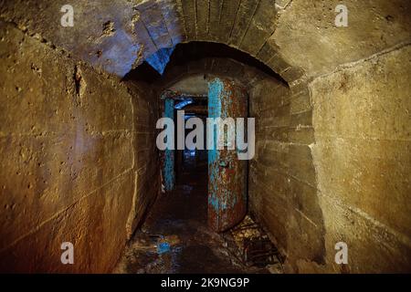 Porta armata in metallo arrugginito nel vecchio bunker sovietico abbandonato. Foto Stock