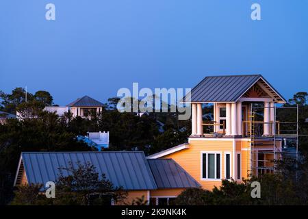 Colorato tramonto blu crepuscolo ora a Seaside, Florida Panhandle città terrazza tetto case edifici, alberi in inverno con costruzione di notte Foto Stock