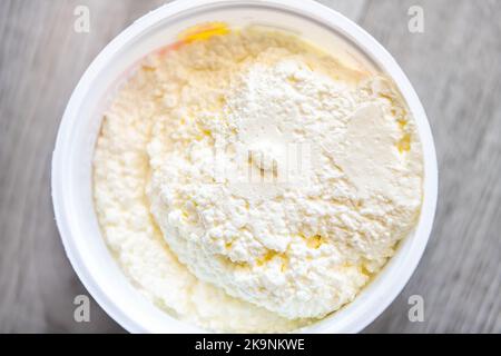 Macro primo piano del contadino russo formaggio latte latte tvorog crema fatta in casa sul tavolo da cucina in legno casa Foto Stock