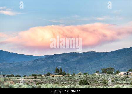 Vista panoramica del tramonto dalle piante di spazzolone di salvia del deserto nella valle di Ranchos de Taos, New Mexico con le montagne di Sangre de Cristo paesaggio delle nuvole estive Foto Stock