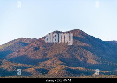 Vista aerea ad alto angolo dell'alto tramonto nel deserto nella valle di Ranchos de Taos, New Mexico con le montagne di Sangre de Cristo in estate Foto Stock