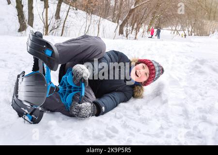 In inverno, un ragazzo guida uno scooter da neve sulla neve. Infanzia felice e stile di vita attivo Foto Stock