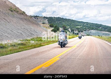 Lonetree, USA - 24 luglio 2019: Arido deserto paesaggio canyon nel Wyoming strada 414 con ciclisti su moto Harley Davidson Foto Stock