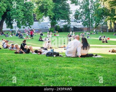 Vienna, Austria - Giugno 2022: Persone, turisti e locali rilassarsi e divertirsi sull'erba verde nel parco Burggarten di Vienna. Foto Stock