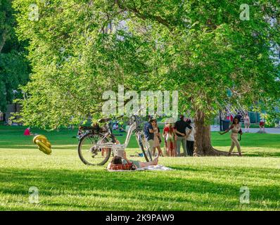 Vienna, Austria - Giugno 2022: Persone, turisti e locali rilassarsi e divertirsi sull'erba verde nel parco Burggarten di Vienna. Foto Stock