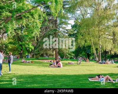 Vienna, Austria - Giugno 2022: Persone, turisti e locali rilassarsi e divertirsi sull'erba verde nel parco Burggarten di Vienna. Foto Stock