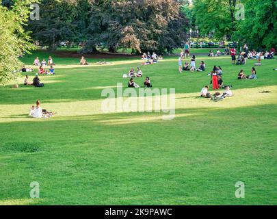 Vienna, Austria - Giugno 2022: Persone, turisti e locali rilassarsi e divertirsi sull'erba verde nel parco Burggarten di Vienna. Foto Stock