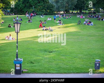 Vienna, Austria - Giugno 2022: Persone, turisti e locali rilassarsi e divertirsi sull'erba verde nel parco Burggarten di Vienna. Foto Stock