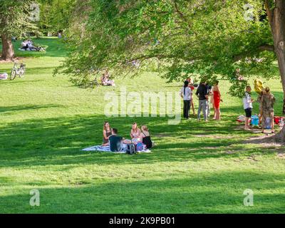 Vienna, Austria - Giugno 2022: Persone, turisti e locali rilassarsi e divertirsi sull'erba verde nel parco Burggarten di Vienna. Foto Stock