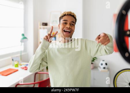 Allegro giovane ragazzo afro-americano che registra video per i social media Foto Stock