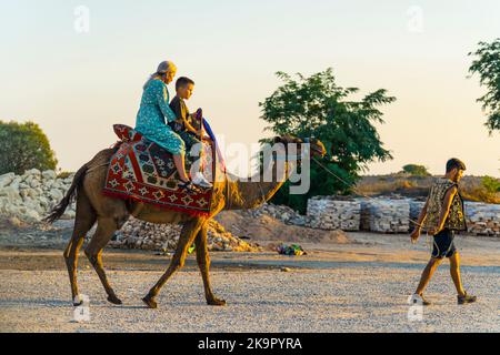 10.10.2022 Side, Turchia. Due turisti - madre caucasica e suo figlio - seduti su una sella su un cammello. Attrazione turistica. Foto di alta qualità Foto Stock