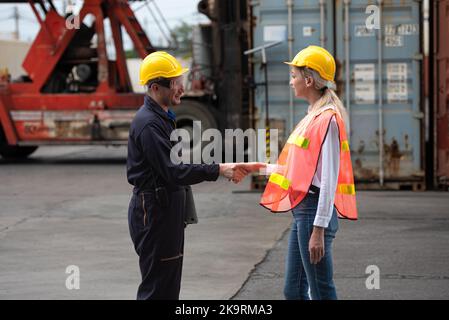 Gli uomini d'affari che scuotono le mani insieme al porto del magazzino merci. Foto Stock