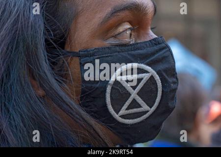 New York, Stati Uniti. 29th Ott 2022. Un attivista del clima indossa una maschera facciale Extinction Rebellion di fronte all'ufficio di New York della nuova sede della JPMorgan Chase Bank durante una protesta di 'Occupy Park Avenue' il 29 ottobre 2022 a New York City. Decine di attivisti del clima, con un grande banner che legge 'Occupy Park Avenue' e cartelli per l'industria dei combustibili fossili, hanno marciato lungo Park Ave dal nuovo quartier generale della JPMorgan Chase Bank alla sede della società di investimenti finanziari BlackRock per protestare contro questi investimenti in combustibili fossili. Credit: Ron Adar/Alamy Live News Foto Stock