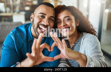 L'amore fa di tutto meglio: Una giovane coppia che fa un gesto cardiaco con le mani all'aperto. Foto Stock