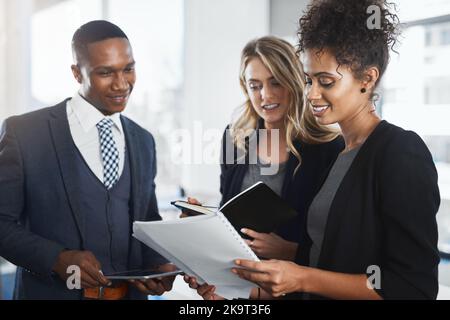 Questo trimestre è stato il nostro migliore finora: Un gruppo di uomini d'affari che lavorano insieme in ufficio. Foto Stock