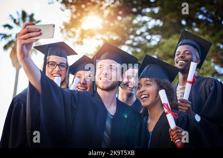 Voglio inquadrare questo: Un gruppo di studenti universitari che prendono un selfie il giorno della laurea. Foto Stock