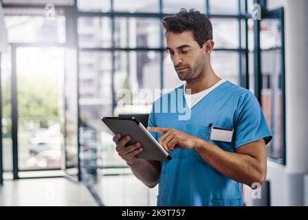 Valutare la salute dei pazienti. Un giovane bel medico maschile che lavora in un ospedale. Foto Stock