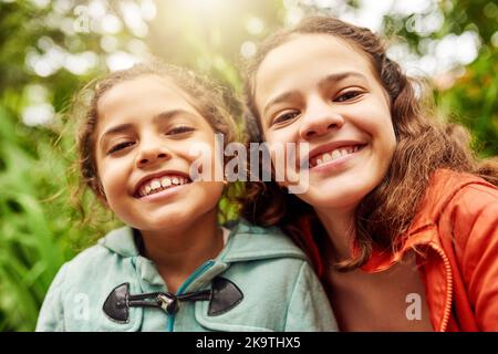 Le sorelle fanno i migliori amici. Ritratto corto di due giovani sorelle che si godono la loro giornata nel parco. Foto Stock