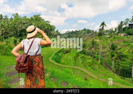 Giovane bella donna che cammina sul crinale Campuhan via degli artisti, a Bali Ubud. Splendida e tranquilla mattina di sole Foto Stock