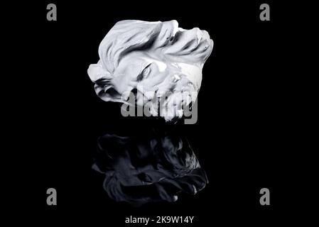 Copia in gesso della famosa statua antica Poseidone testa isolata su uno sfondo bianco. Intonaco scultura antica volto giovane uomo. Epoca rinascimentale. PORTRA Foto Stock