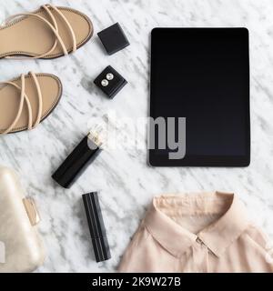 Moda e bellezza blog concetto. Diversi accessori femminili, abbigliamento, scarpe, borsa, trucco , profumo e tablet con spazio copia sul retro moderno beige Foto Stock