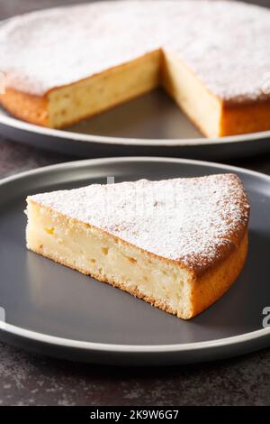 Torta di yogurt o gateau au yaourt è un classico francese cotto bene con glassa zucchero closeup in un piatto su un tavolo. Verticale Foto Stock