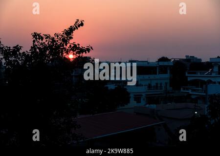 febbraio 12th 2022 Dehradun città India. Tramonto da un tetto con il paesaggio della città e il sole sullo sfondo. Foto Stock