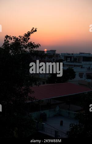 febbraio 12th 2022 Dehradun città India. Tramonto da un tetto con il paesaggio della città e il sole sullo sfondo. Foto Stock