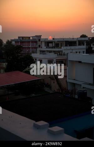 febbraio 12th 2022 Dehradun città India. Tramonto da un tetto con il paesaggio della città e il sole sullo sfondo. Foto Stock