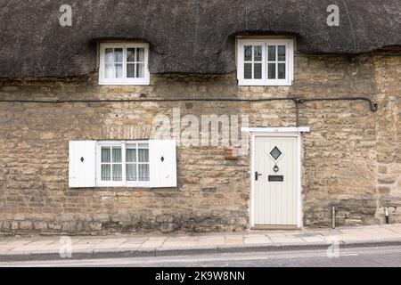 DORSET, Regno Unito - 06 luglio 2022. Di fronte a un cottage in paglia di pietra su una strada nel villaggio di Corfe Castle, Dorset, Regno Unito Foto Stock