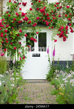 BUCKINGHAMSHIRE, Regno Unito - 03 giugno 2022. Esterno di casa cottage inglese e giardino con rose rampicanti intorno alla porta d'ingresso. Inghilterra, Regno Unito Foto Stock