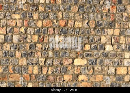 Una pietra grigia gialla fatta di lastre di pietra e arenaria sfondo, pietra sconnessa muratura texture, struttura rocciosa sfondo Foto Stock