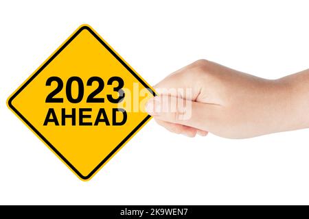 2023 Year Ahead Traffic Sign in Woman's Hand su sfondo bianco Foto Stock