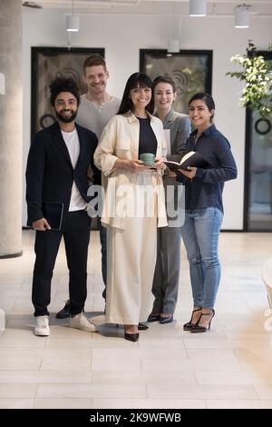 Il personale aziendale posa in uno spazio di lavoro moderno e sorridi a guardare la macchina fotografica Foto Stock