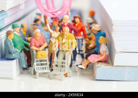 Giocattolo in miniatura di coppia di anziani su un concetto di trasporto pubblico - viaggiare su un treno o autobus. Foto Stock