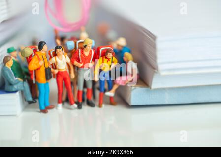 Figurine in miniatura di coppie di backpackers viaggiare su un trasporto pubblico - concetto di viaggio a basso costo. Foto Stock