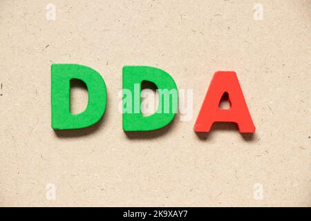 Lettera alfabetica a colori in parola DDA (abbreviazione di deprezzamento, esaurimento e ammortamento o conto deposito della domanda) su sfondo legno Foto Stock
