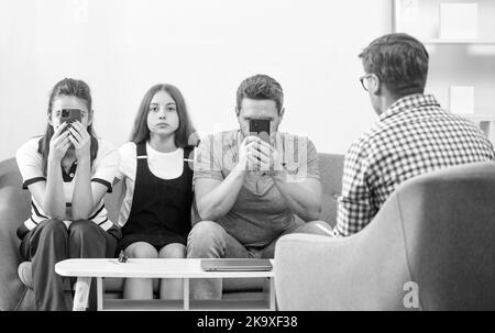 capretto con il papà addicted del telefono e la mamma seduta allo psicologo che risolve il problema, il rapporto Foto Stock
