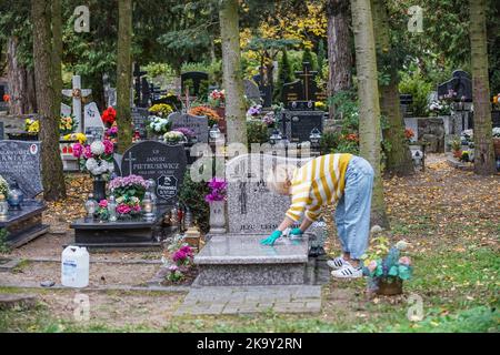 Danzica, Polonia. 30th Ott 2022. Si vedono le persone che visitano le tombe dei loro parenti al cimitero di Lostowicki. Il popolo cristiano celebra la Giornata dei Santi (Wszystkich Swietych), rispetta i membri della famiglia morti, deposisce fiori e candele accese sulle tombe. La Giornata dei Santi il 1 novembre e la Giornata delle ANIME il 2 novembre sono le festività in cui milioni di polacchi visitano le tombe dei propri cari, spesso percorrendo centinaia di chilometri fino alle loro città d'origine. Nel 2022 come il 1st novembre è il Martedì molte persone visitano tombe nel fine settimana che precede quel giorno. Credit: Vadim Pacajev/Alamy Live News Foto Stock