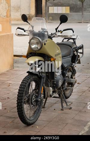 Barcellona, Spagna - 23 ottobre 2022: Una motocicletta reale Enfield Himalayan con una ruota knobby e fango, parcheggiata sul marciapiede Foto Stock