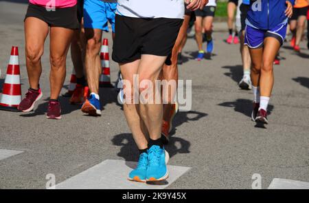 Corridori atletici con gambe muscolose durante la corsa competitiva in città Foto Stock