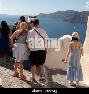 Santorini, Grecia. 2022. Turisti che si affacciano sul Mar Egeo dalla cima di Oia, isola di Santorini. Foto Stock