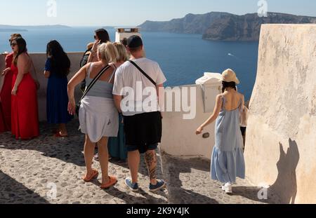 Santorini, Grecia. 2022. Turisti che si affacciano sul Mar Egeo dalla cima di Oia, isola di Santorini. Foto Stock